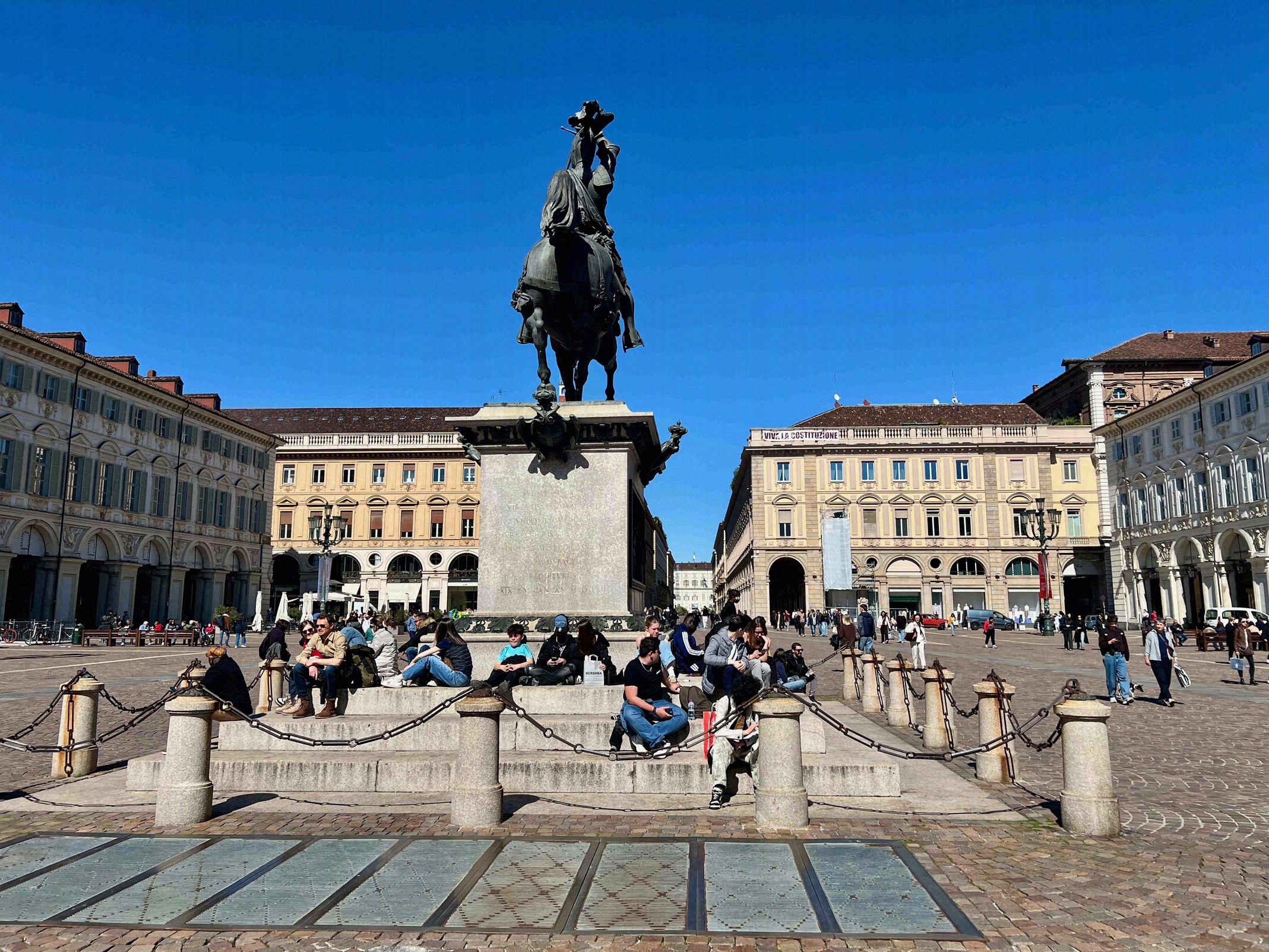 Reiterstandbild Emanuele Filibertos ("Caval ëd Brôns") auf der Piazza San Carlo, umgeben von barocken Fassaden und Besuchern.